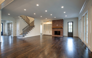 Living room with stairwell and fireplace and custom shelving