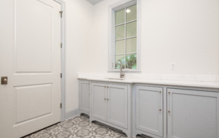 Custom laundry room with sink and door to exterior
